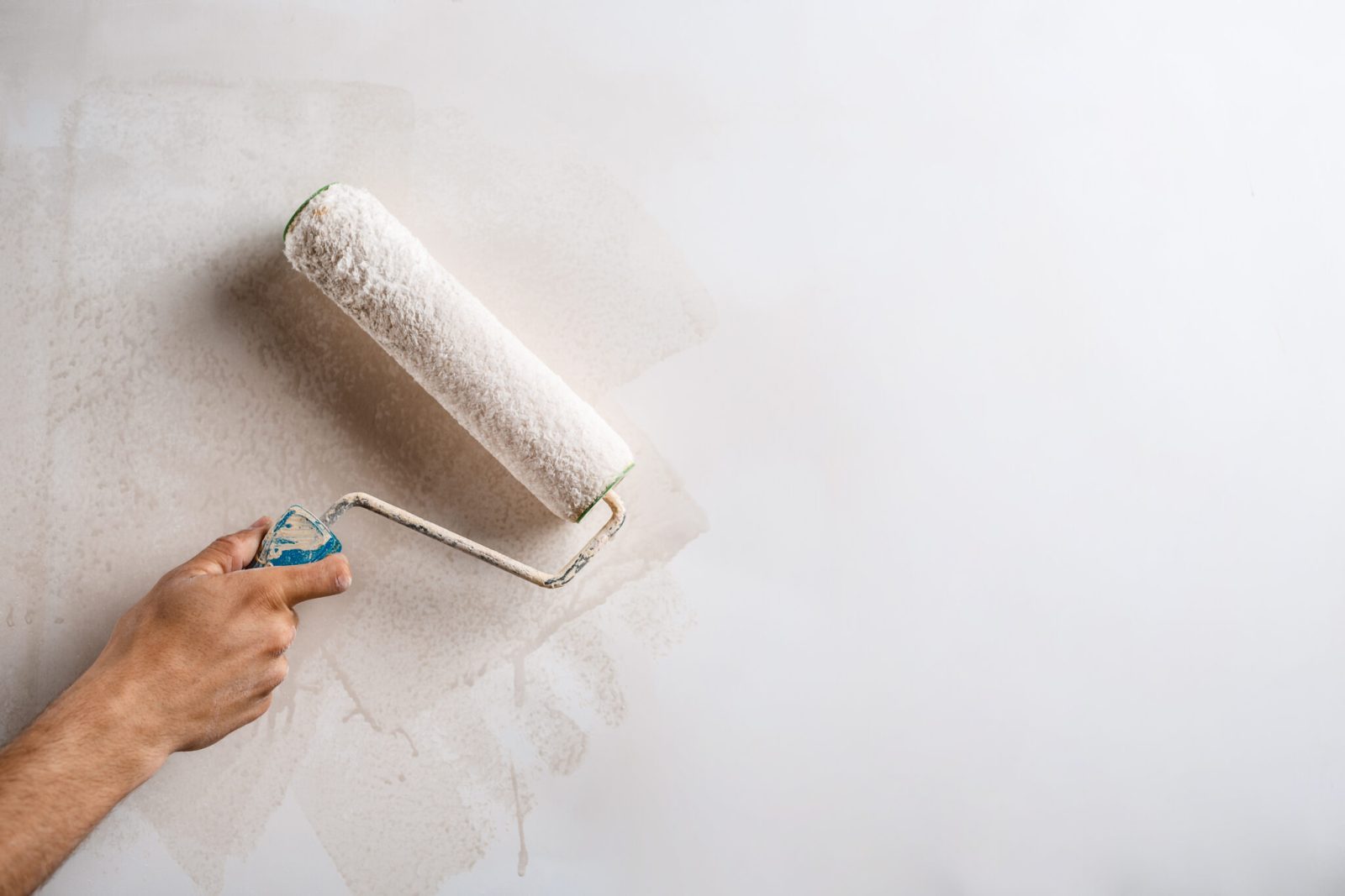 Painter using a paint roller on an interior wall on the Central Coast NSW